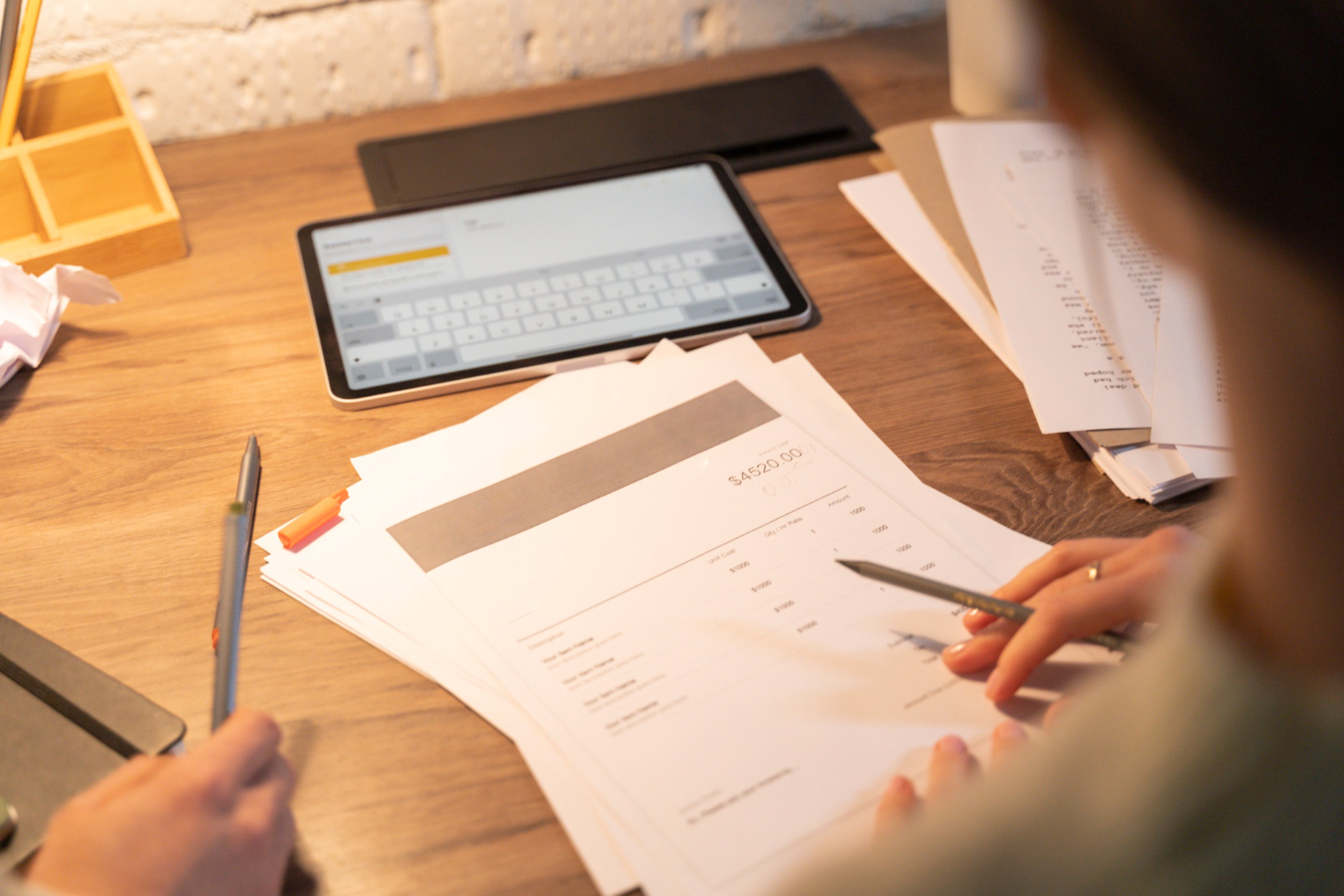 Daniel Bousquet gère des documents financiers à Toulouse dans un bureau chaleureux, stylo à la main,