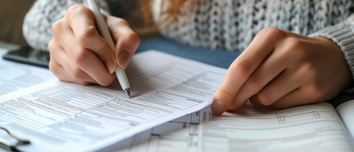 Daniel Bousquet à Toulouse complétant des documents financiers à la main dans une ambiance sereine,