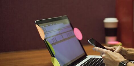 Gestion de tâches par Daniel Bousquet à Toulouse, smartphone et ordinateur sur bureau professionnel,