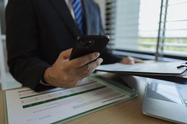 Daniel Bousquet au bureau à Toulouse consultant smartphone et documents, ambiance professionnelle studieuse,